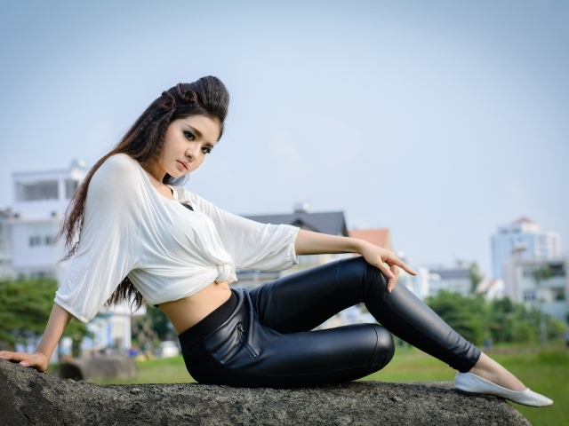 Девушка азиатка в черных кожаных брюках