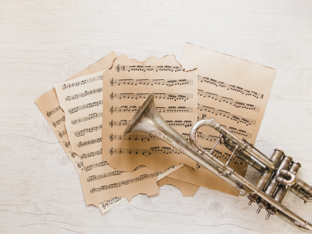 Труба и старые ноты на столе