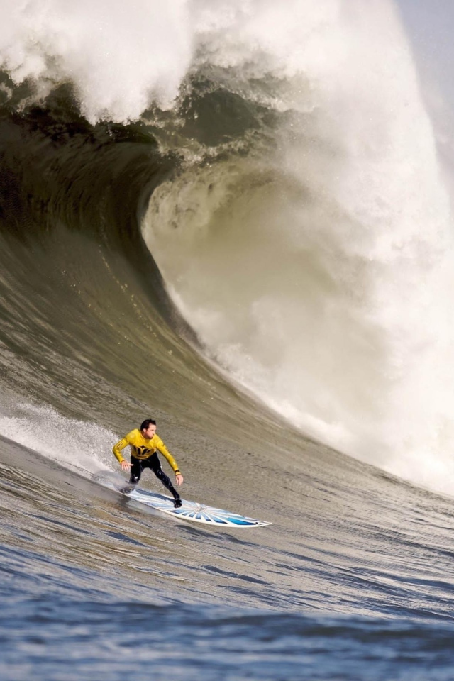 Серфер спускается с волны