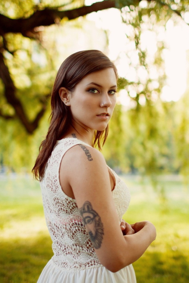 Брюнетка с татуировкой на природе