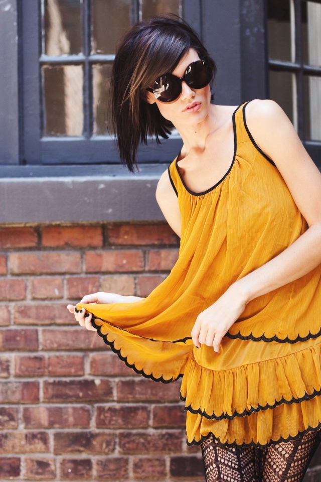 Девушка в желтом платье и черных чулках