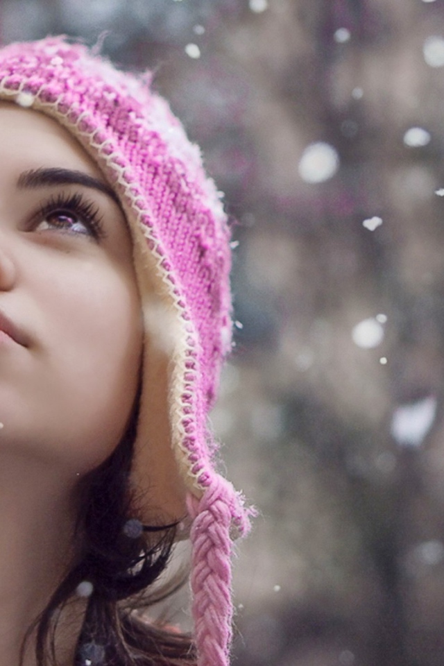 Девушка смотрит на падающий снег