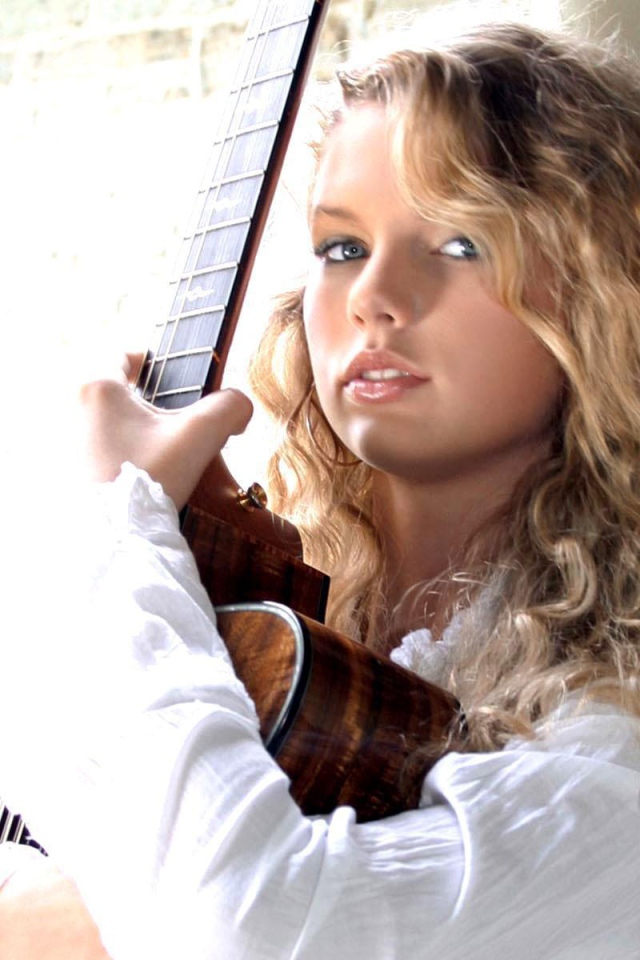 Taylor Swift обнимает свою гитару