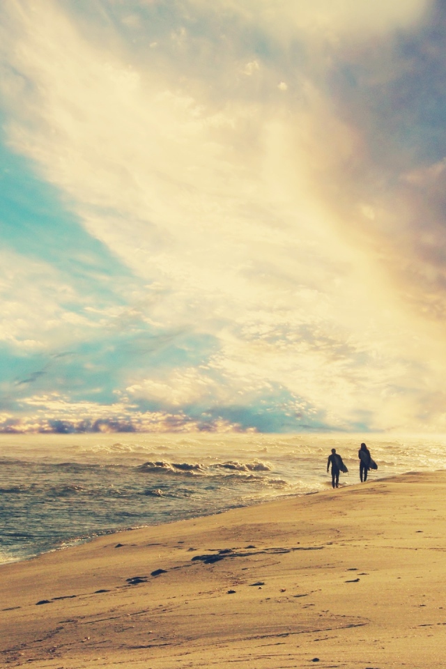 Двое идут по солнечному пляжу