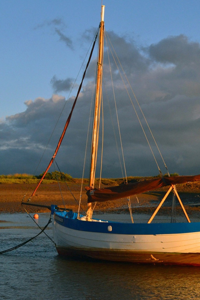 Парусная лодка стоит у берега