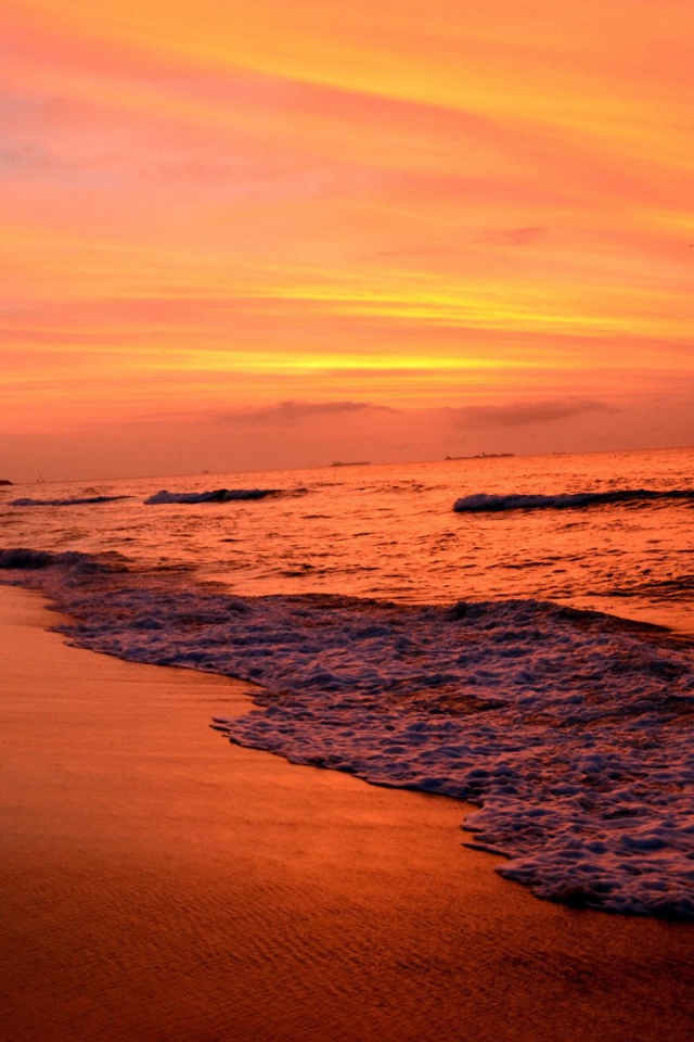 На закате волны лижут пляж