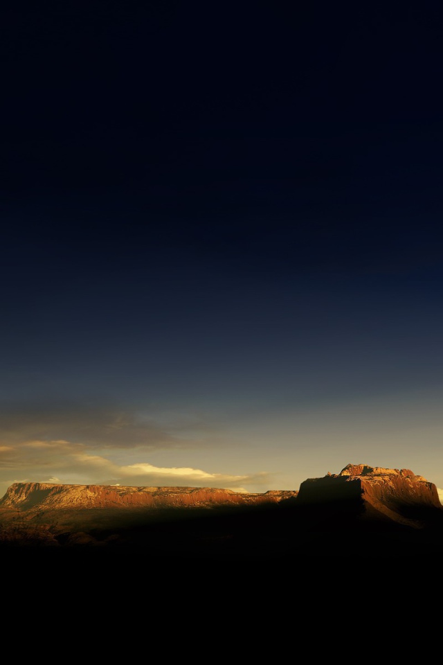 Солнце на закате освещает гору