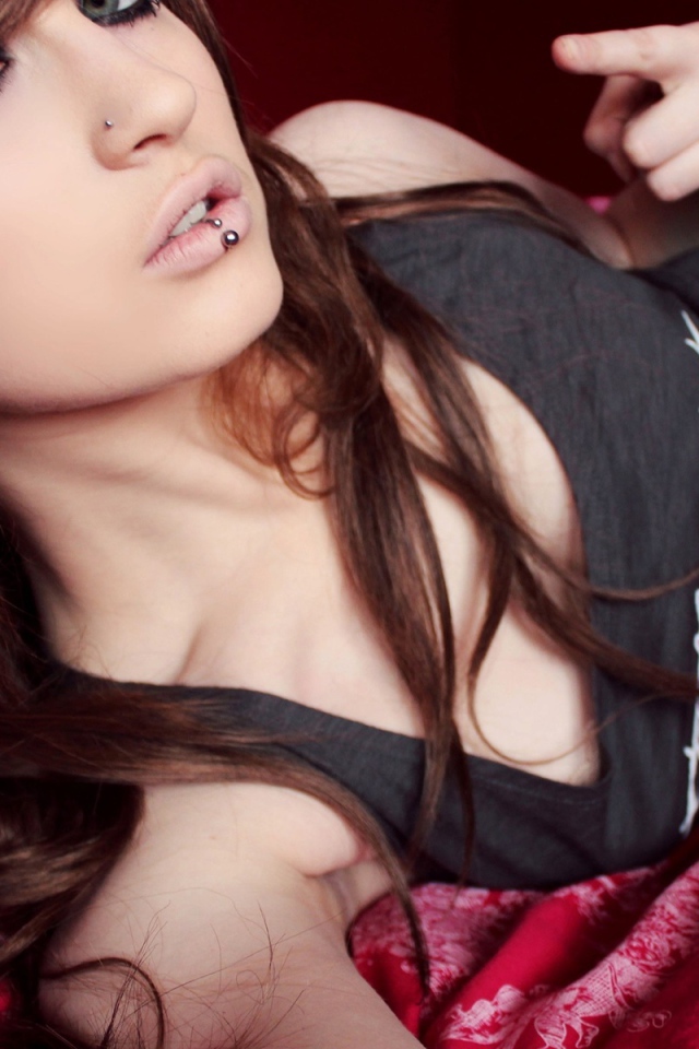 Красивая девушка шатенка с пирсингом в носу и губе