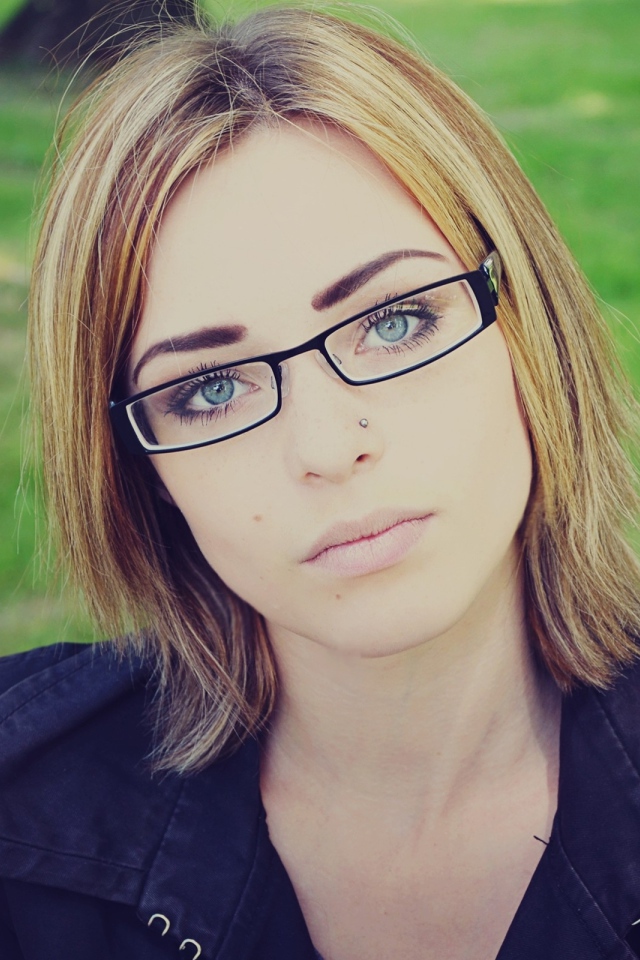 Девушка блондинка с пирсингом в носу в очках
