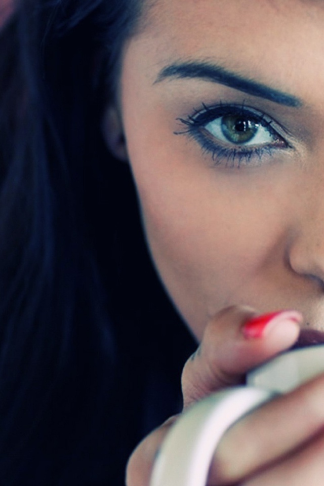 Девушка брюнетка с пирсингом в носу и красными ногтями