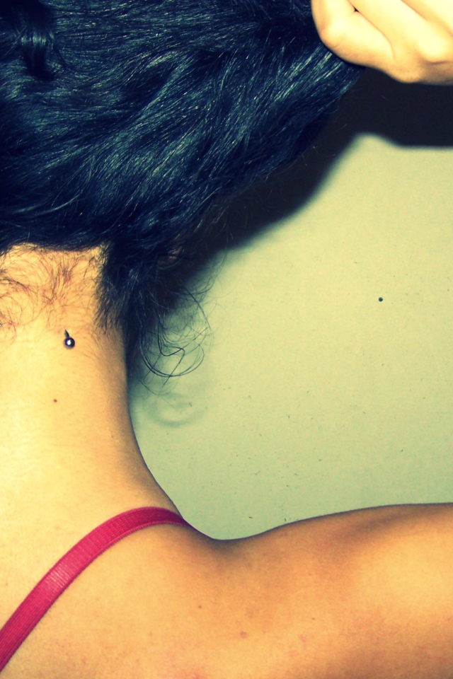 Девушка брюнетка с пирсингом в шее