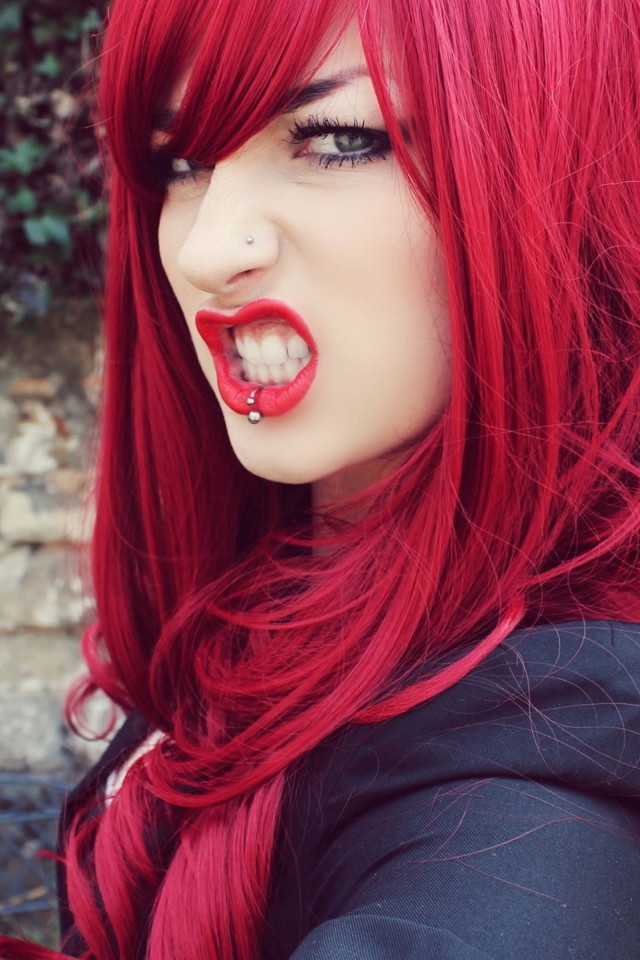 Девушка с красными волосам и пирсингом в носу и губе