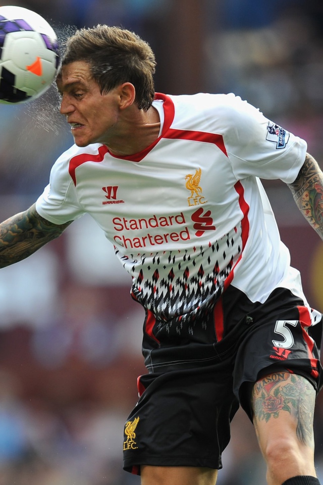 The player of Liverpool Daniel Agger is hitting a ball