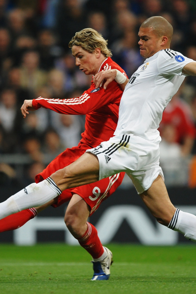 Игрок из Реал Мадрид Пепе пытается взять мяч