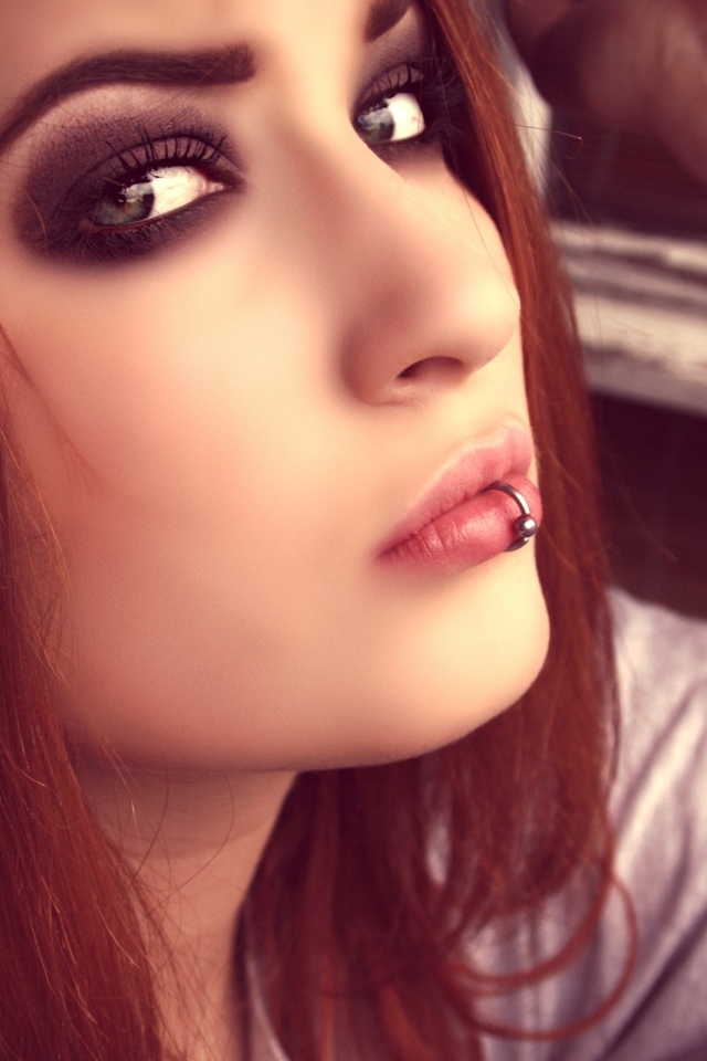 Молодая девушка шатенка с пирсингом в губе