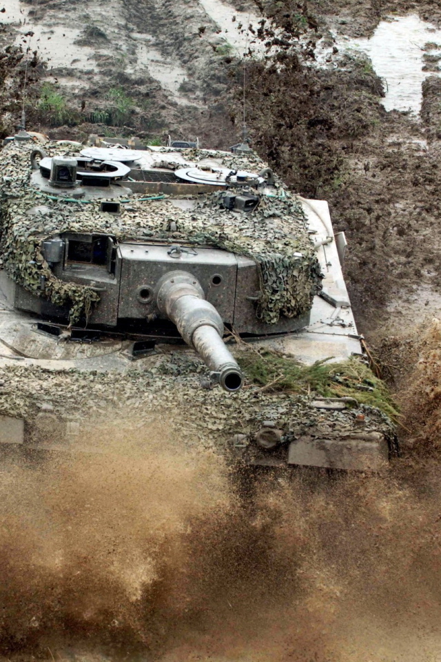 Танк в маскировке едет по грязи