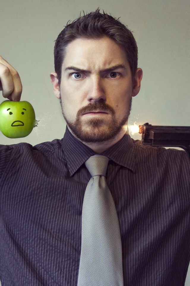 Мужчина стреляет в яблоко