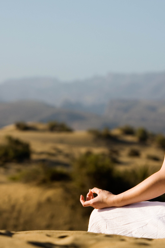 Девушка медитирует на холме