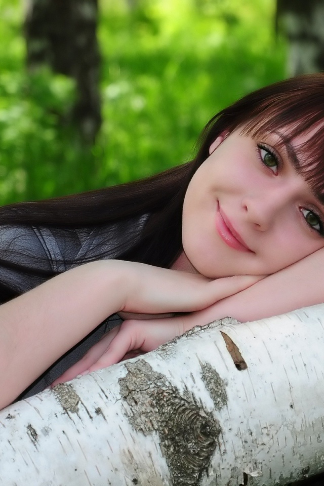 Девушка улыбается в лесу