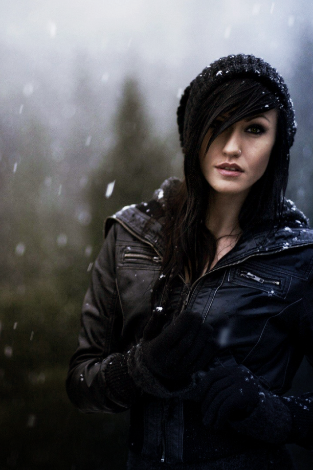 Брюнетка в куртке под снегом