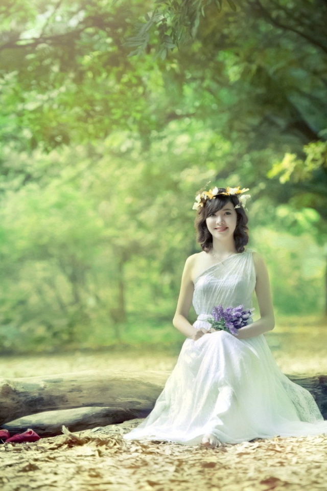 Девушка сидит на бревне