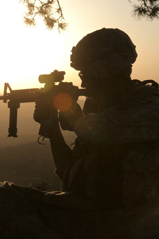 Солдат с оружием на закате