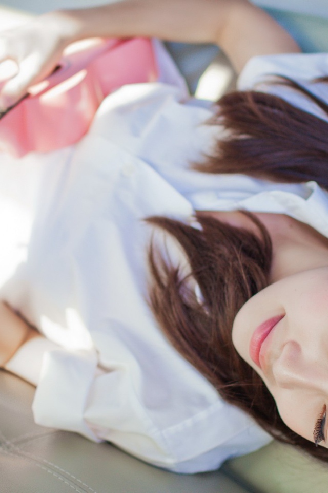 Брюнетка и розовая гитара на диване