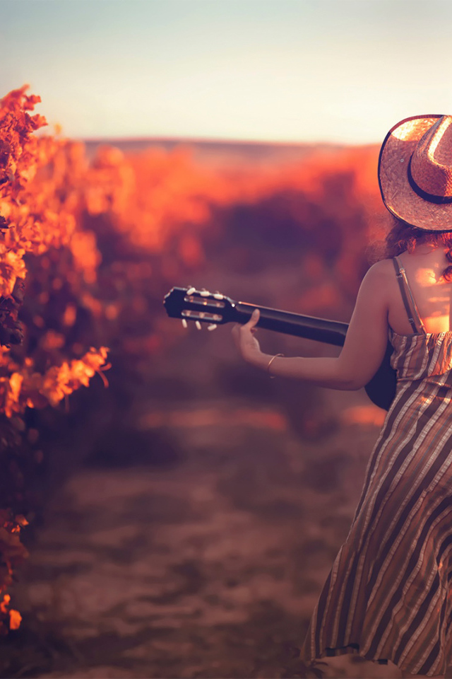 Девушка с гитарой в винограднике