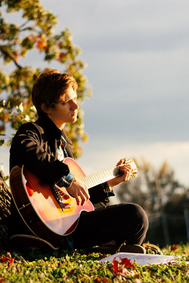 Парень с гитарой у дерева