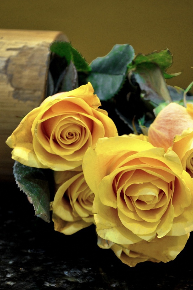 Жёлтые розы на тёмном столе