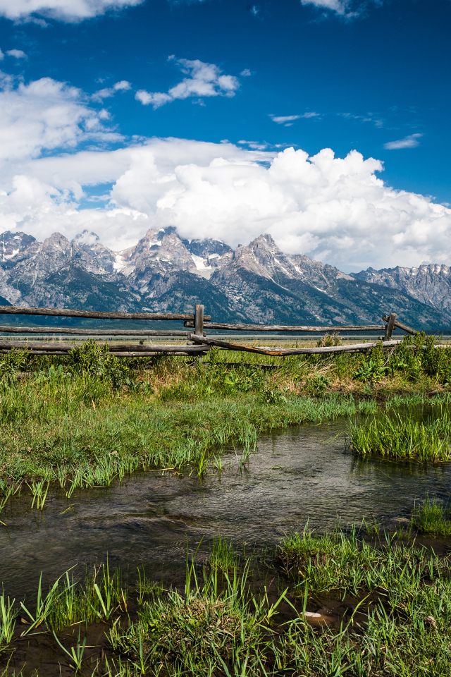 Деревянная ограда на фоне величественных гор