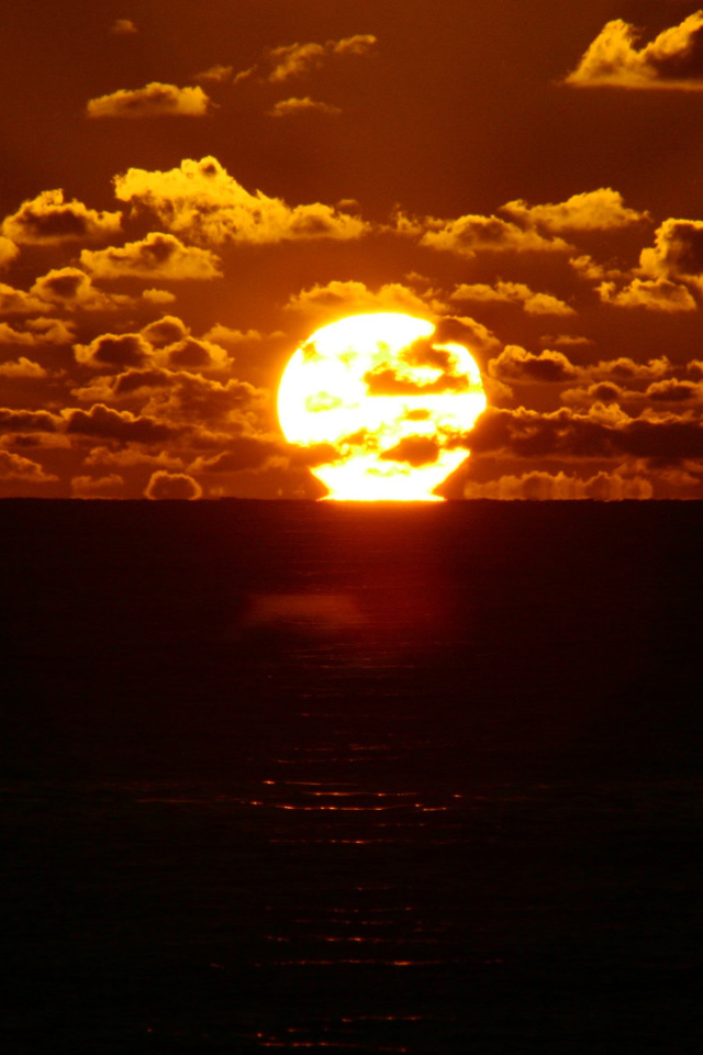 Солнце между небом и морем