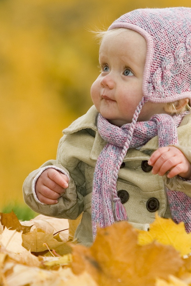 Ребенок играет осенними листьями