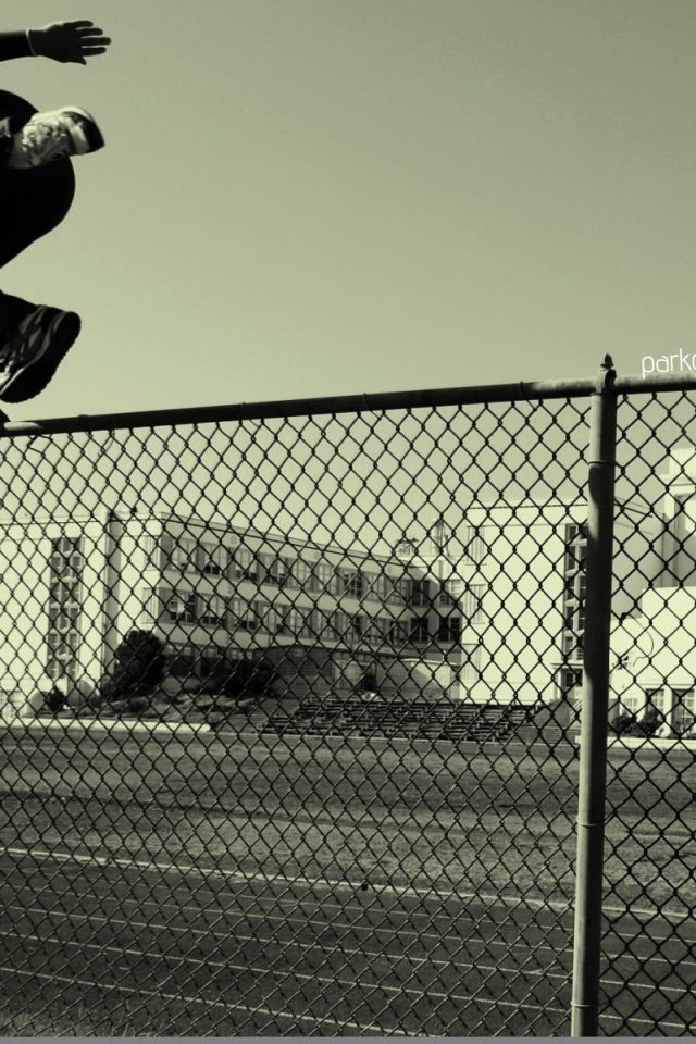 Паркурщик прыгает через забор