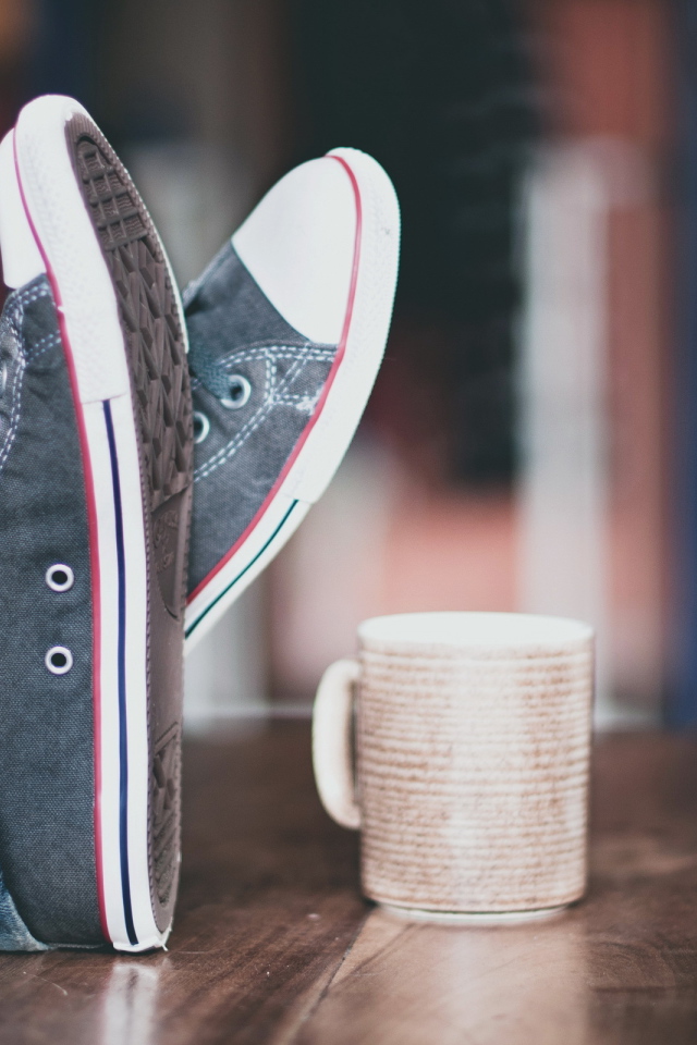 Кеды и чашка на столе