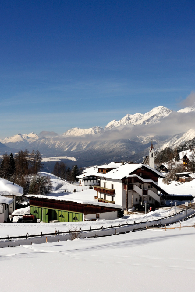 Дома на фоне гор на курорте Зеефельд, Австрия