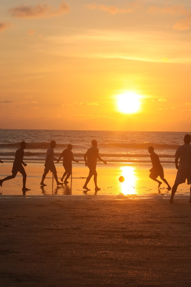 Парни играют в футбол на пляже в Гоа