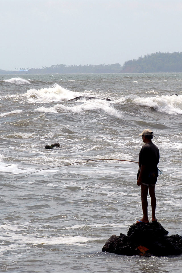 Мужчина ловит рыбу в Гоа