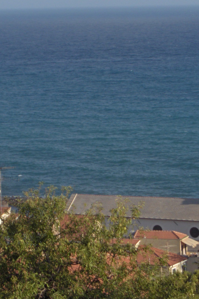 Башня с часами на фоне моря в Санто Стефано аль Маре, Италия