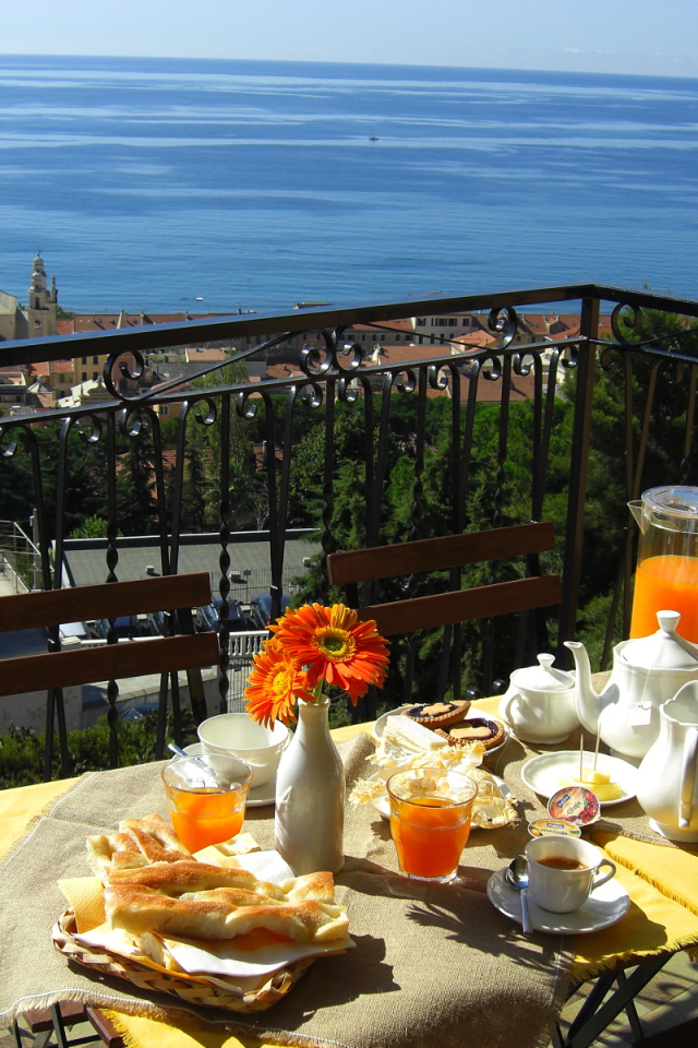 Отдых в кафе на террассе на курорте в Пьетра Лигуре, Италия