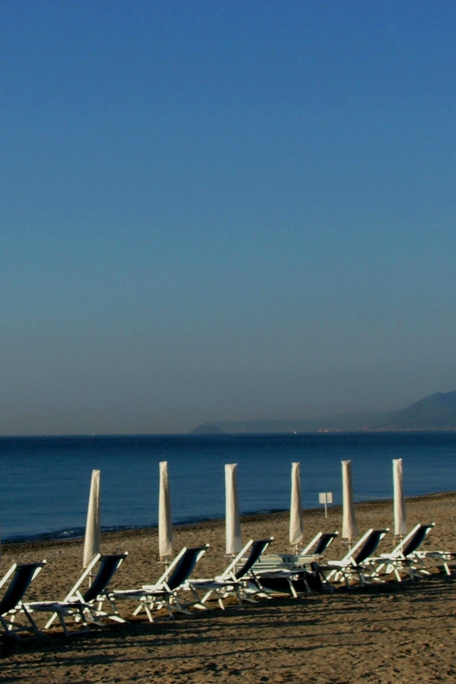 Лежаки на пляже на курорте Финале Лигуре, Италия