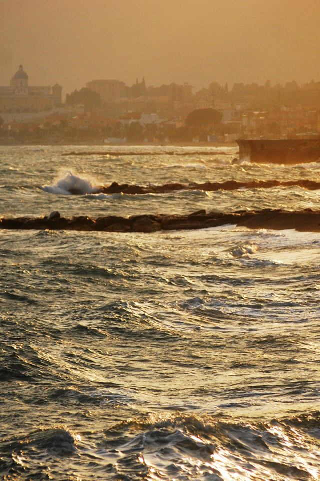 Закат на пляже на курорте в Пьетра Лигуре, Италия