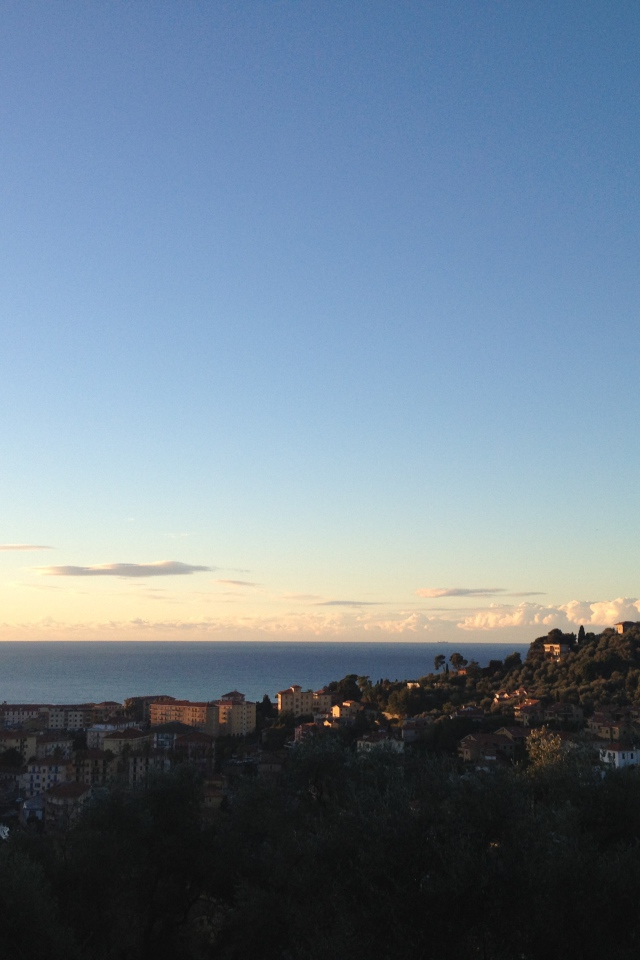 Закат над городом на курорте Империя, Италия