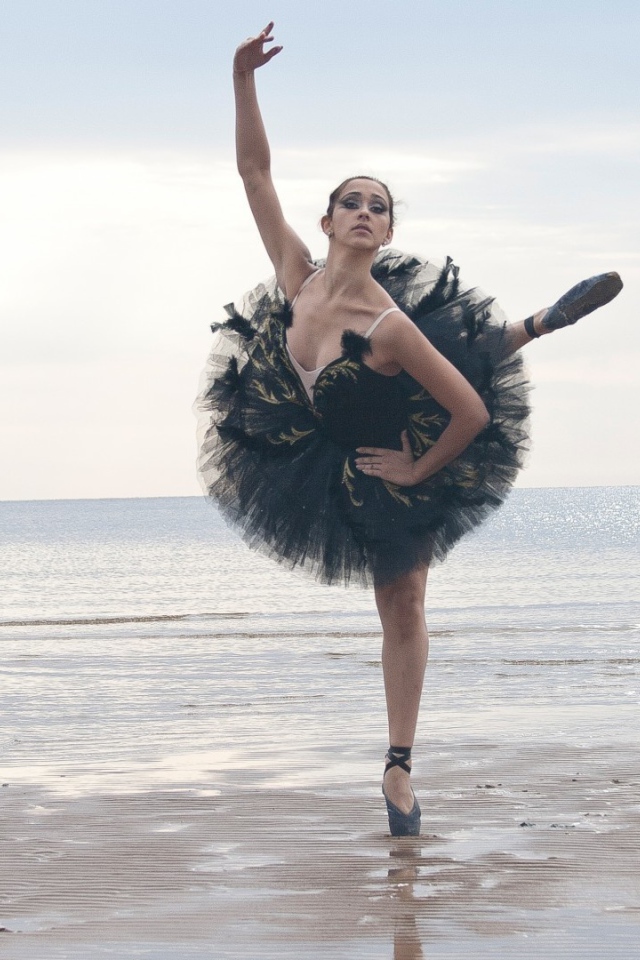 Балерина в черном на пляже