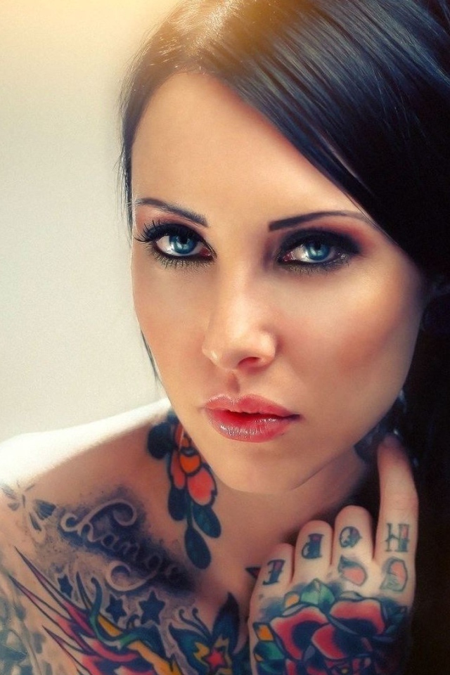 Голубоглазая девушка с татуировкой на руке и плече