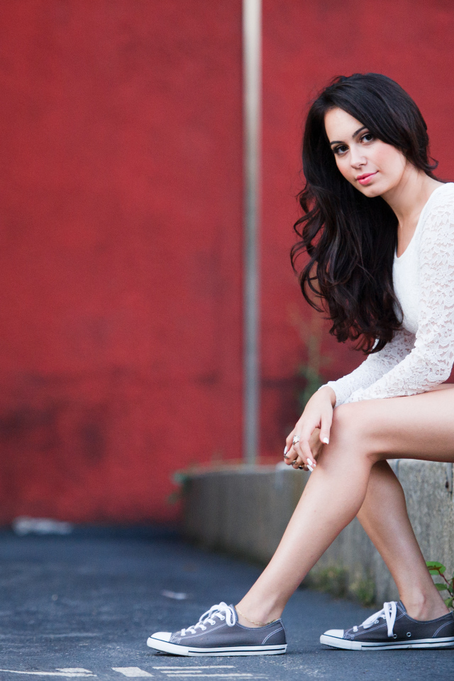 Брюнетка в кедах на бордюре
