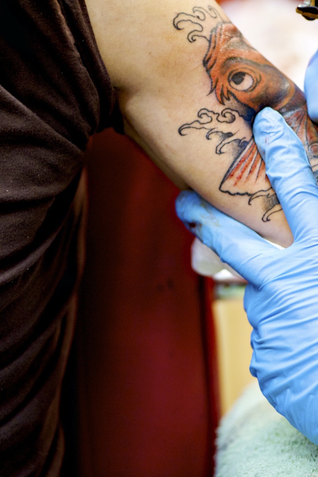 Девушке делают татуировку