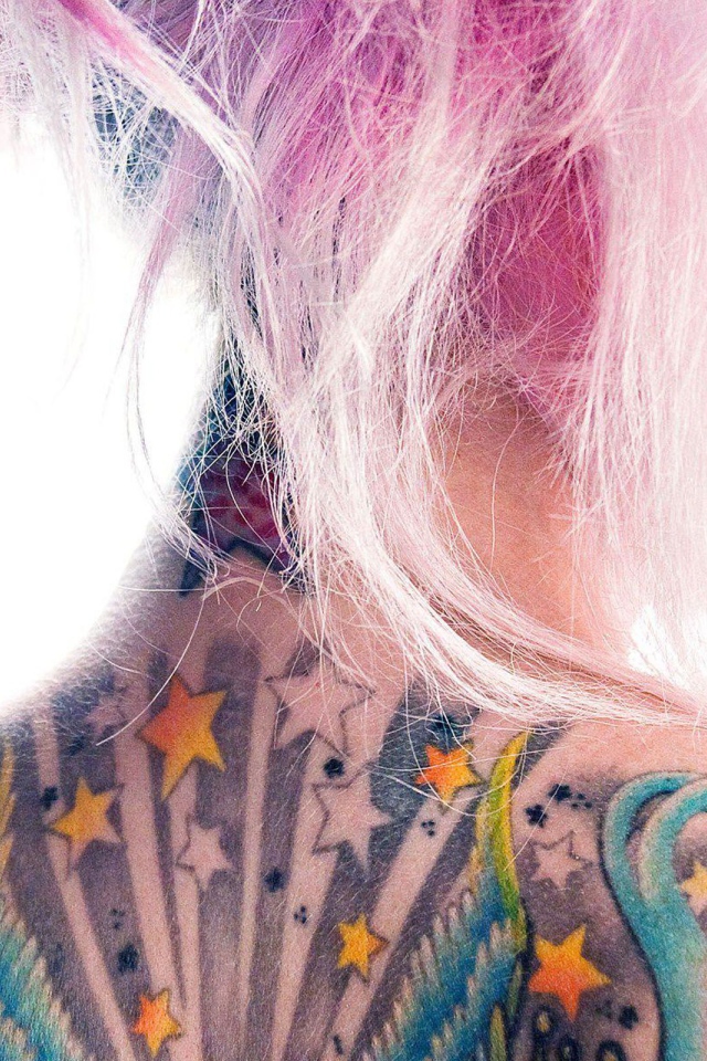 Девушка с розовыми волосами и татуировкой на спине