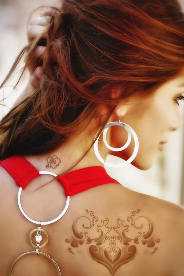 Девушка с татуировками на плече и шее