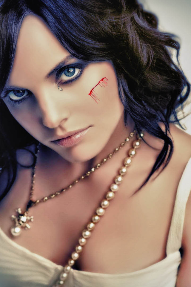 Шрам на щеке и татуировка на плече у девушки